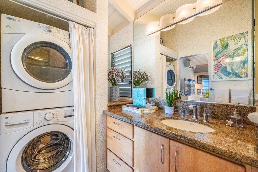Wailea Ekolu 1106 bathroom with vanity, washer, dryer, and sleek modern fixtures.
