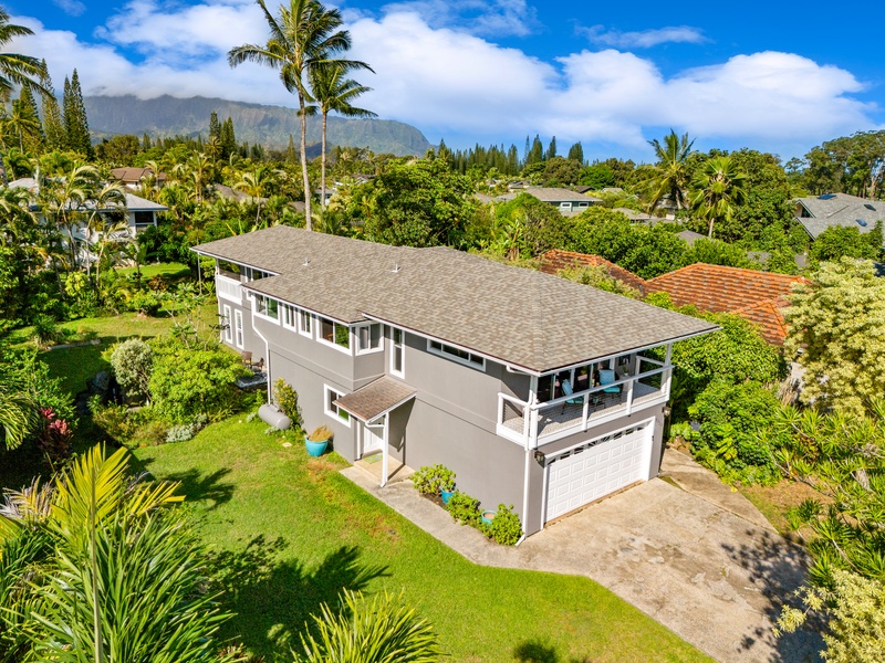 See the home from above, surrounded by trees and mountains.