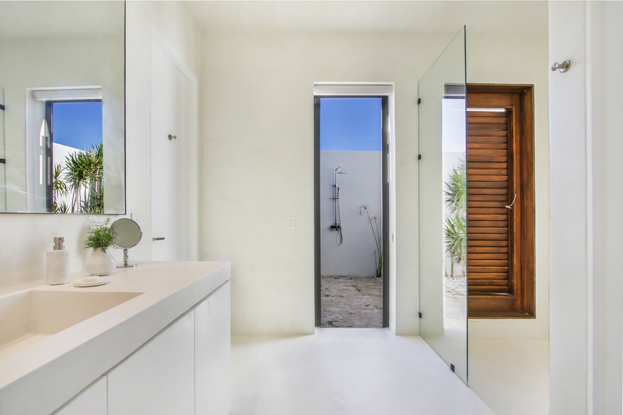 Sleek ensuite bathroom with easy access to an outdoor shower.