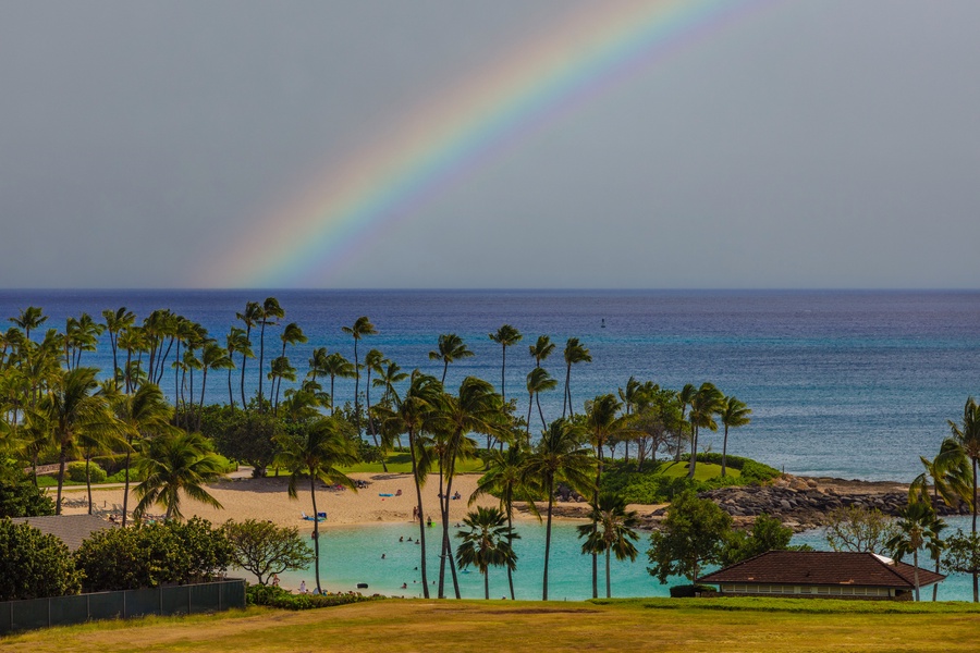 Rainbow arching over a tropical beachfront, a blend of nature's magic and tranquility.