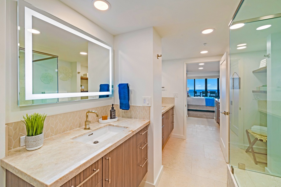 The spacious bathroom features a dual-sink vanity with elegant lighting, perfect for getting ready with ease.