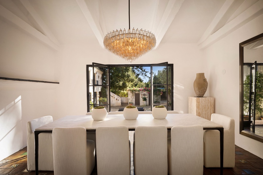 Your elegant dining room features vaulted ceilings, a stunning chandelier, and opens to beautiful garden views through floor-to-ceiling windows.