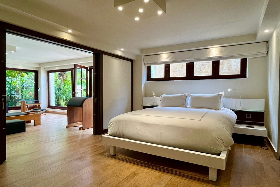 Spacious guest bedroom with natural light and private gym access.