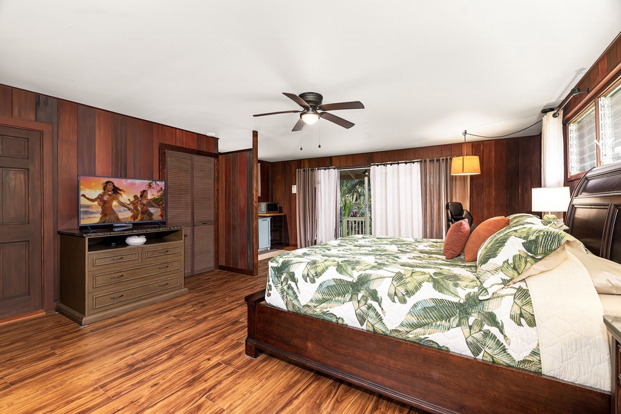 The spacious bedroom with tropical-style bedding, warm wood accents, a ceiling fan, and your own TV for relaxed evenings after island adventures.