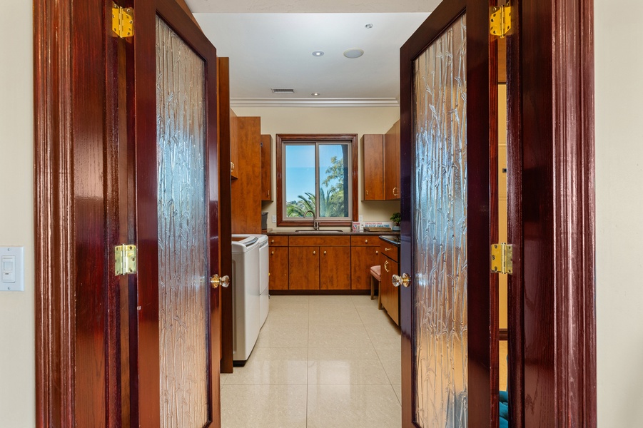 Down the wood-lined passage, a window opens onto the laundry room at the end.