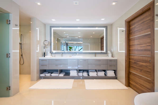Primary bathroom with dual sinks, backlit mirrors, and ample storage—luxury meets function.