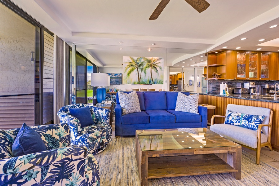 The living area offers a comfortable retreat with a vibrant blue sofa and tropical accents