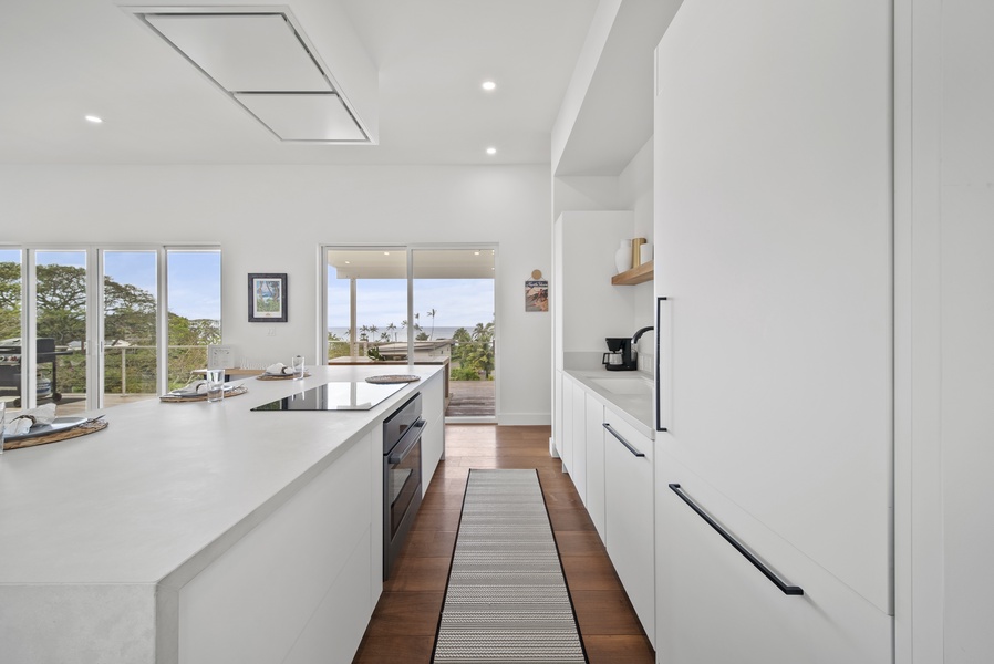 Prepare meals in the sleek, open kitchen while enjoying lush outdoor scenery.