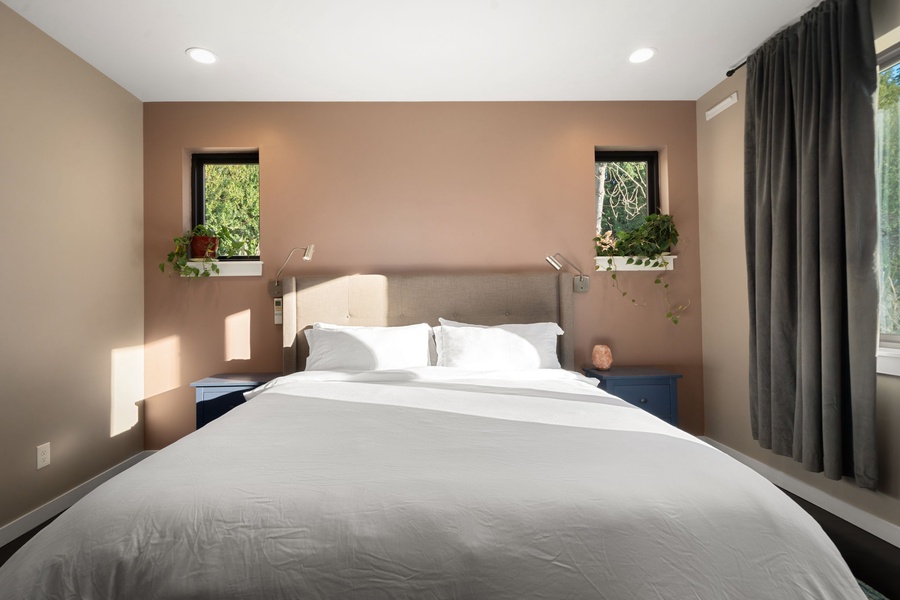 Sink into crisp white linens and feel the warm morning light dance across your peaceful retreat, surrounded by gentle earth tones.