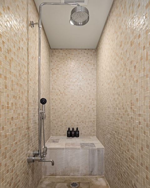 Step into your luxurious tiled shower with modern fixtures and built-in bench for pure relaxation.