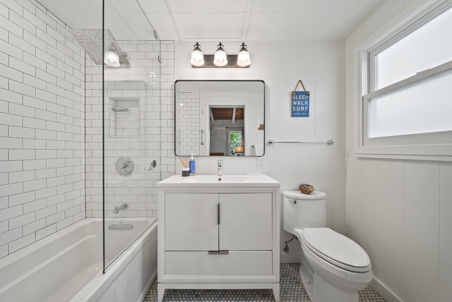 Ensuite bathroom featuring a modern vanity and bright lighting—ideal for refreshing after beach days or surf sessions.