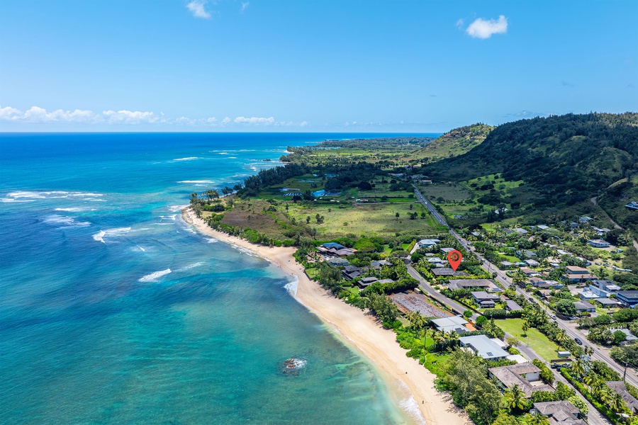 Drone view down the coast showcasing the stunning North Shore curve and endless beachline.