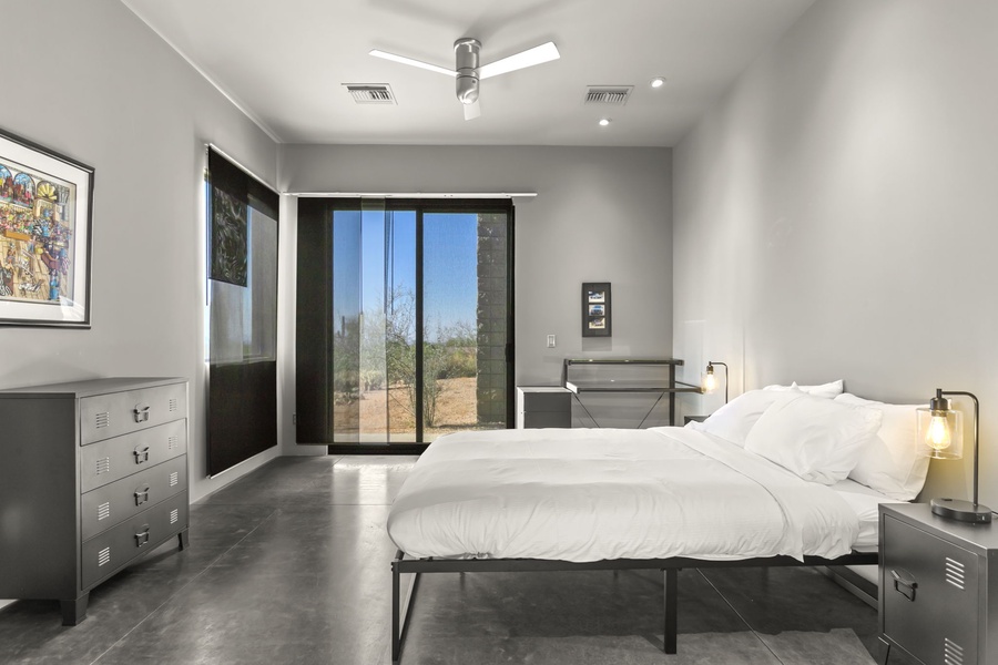 Minimalist bedroom design with sleek furnishings and sliding doors that open to outdoors.