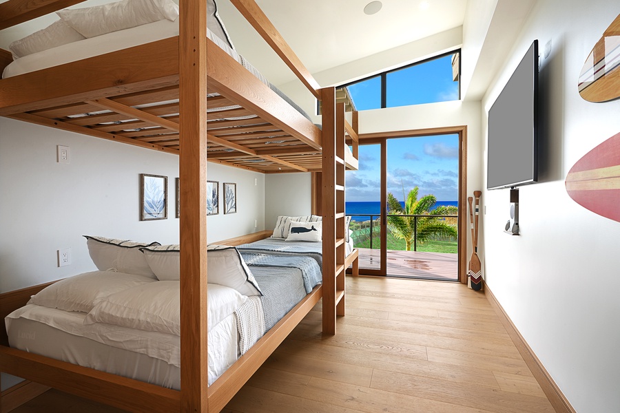 The bunk bedroom with sleeping for eight, floor-to-ceiling glass windows and access to private lanai.