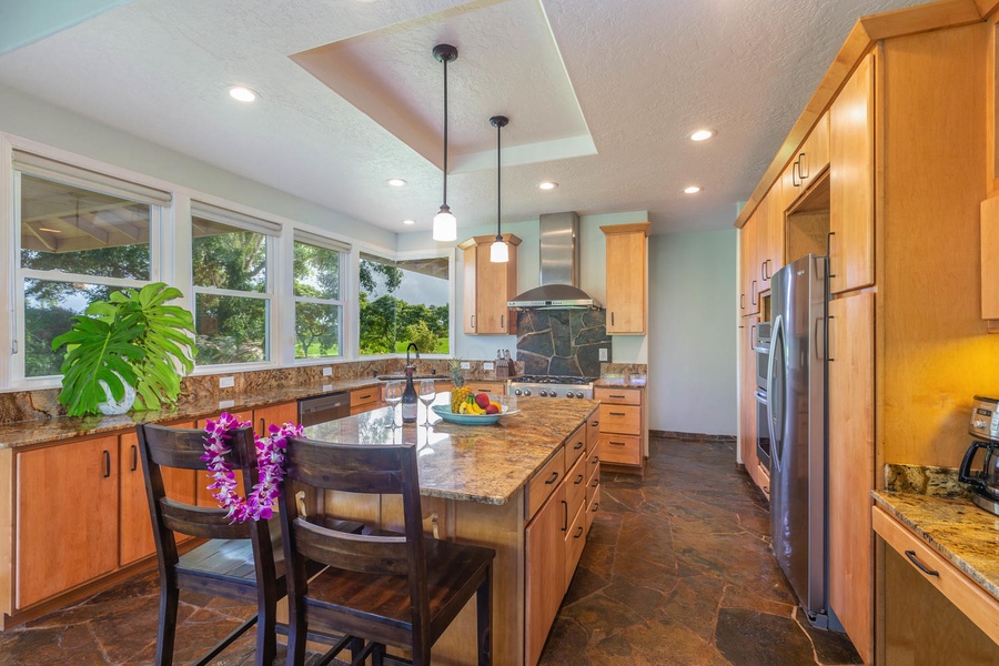 The kitchen at Pohaku Villa offers generous counter space, pendant lighting, and bar seating for casual dining.