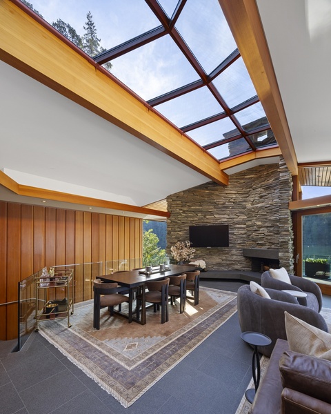 Your open-concept living space features a stunning glass ceiling that floods the room with natural light, creating an airy atmosphere perfect for relaxation.