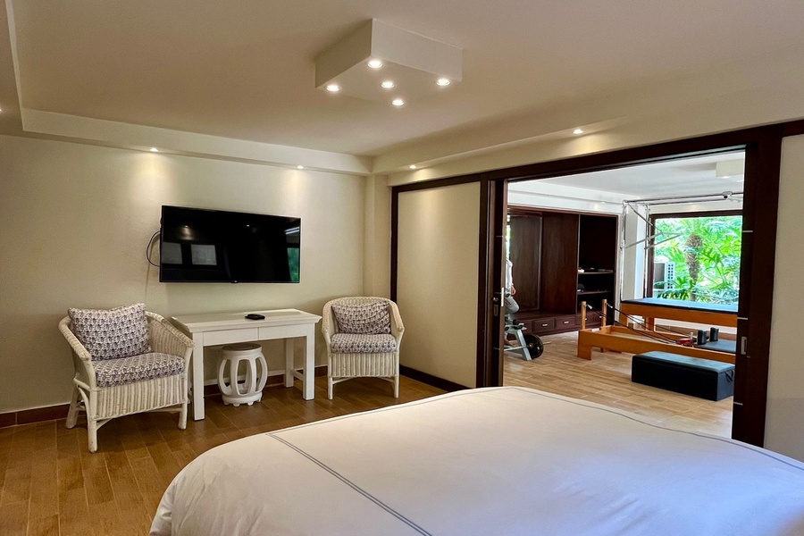 The guest bedroom also features a large TV and a cozy seating area.