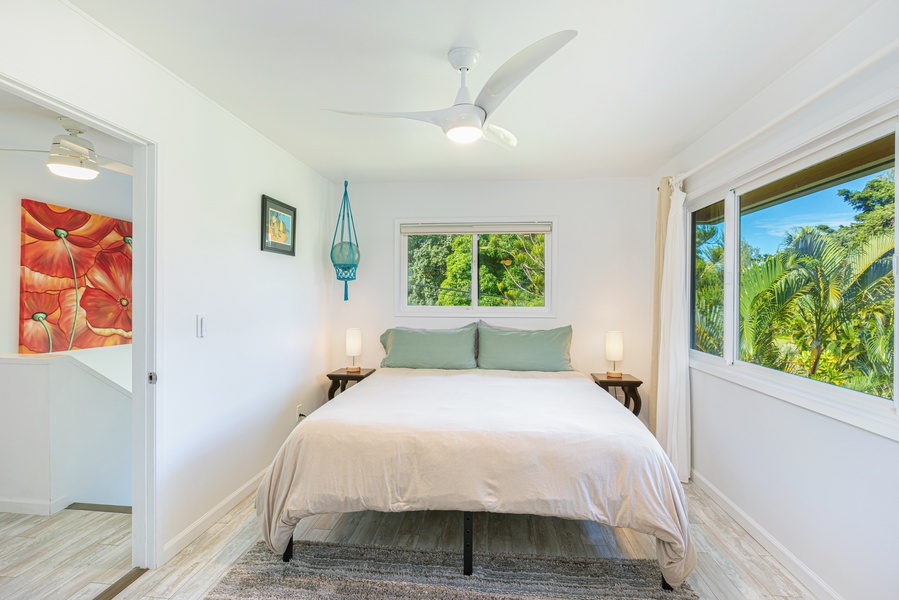 Primary bedroom with King bed, Central A/C, ceiling fan, and lush tropical views.