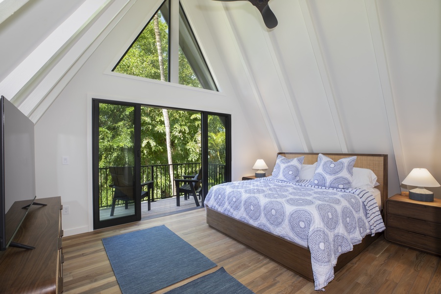 A-frame third guest bedroom with a vaulted ceiling, cozy bedding, and plenty of natural light.