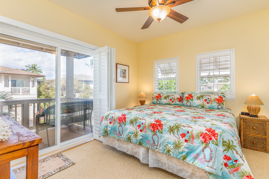 The second guest bedroom with TV, floral prints and lanai access.
