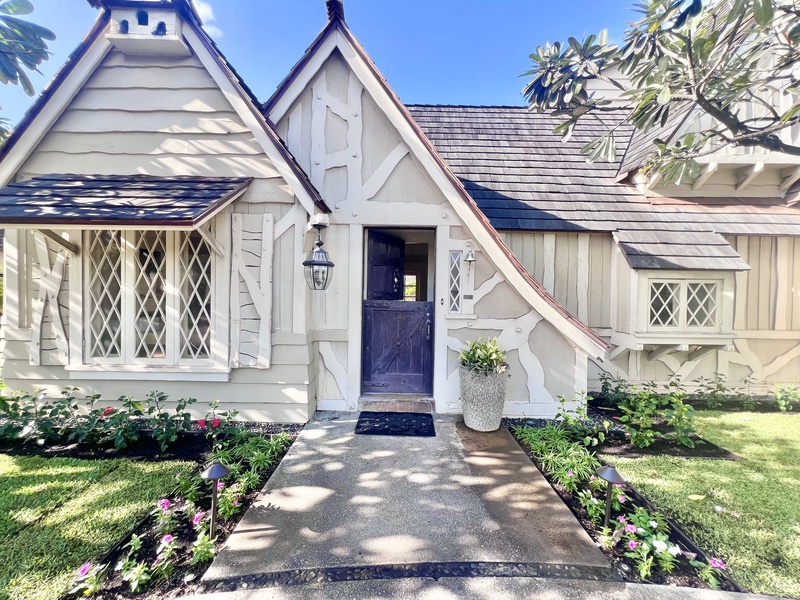 Beautiful front entry with intricate architectural details, framed by lush gardens for a warm and inviting welcome.