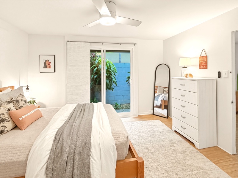 Unwind in your serene bedroom sanctuary with cozy bedding, thoughtful touches, and peaceful garden views from your private patio doors.