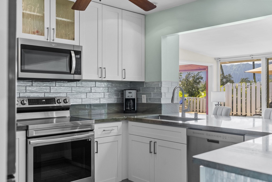 Whip up gourmet meals in this fully-stocked kitchen featuring pristine white cabinetry.