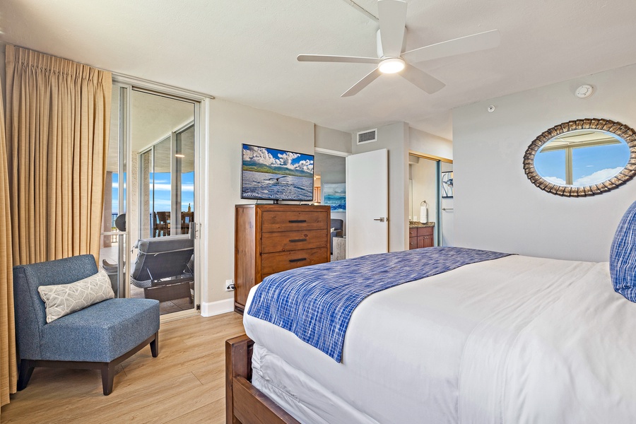 This spacious bedroom features comfortable bedding, modern decor, and direct access to a private lanai for added relaxation.