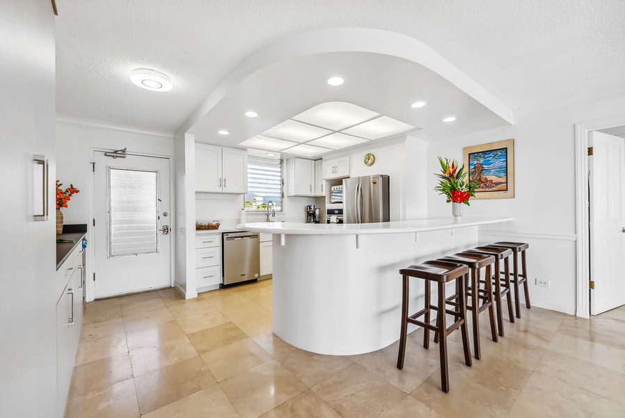 Bright, open kitchen with bar seating, modern appliances, and plenty of counter space—perfect for cooking and gathering.