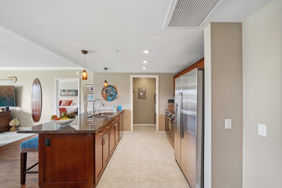 A bright galley-style kitchen at Honua Kai Konea 204 connects beautifully to the rest of the open-concept home.