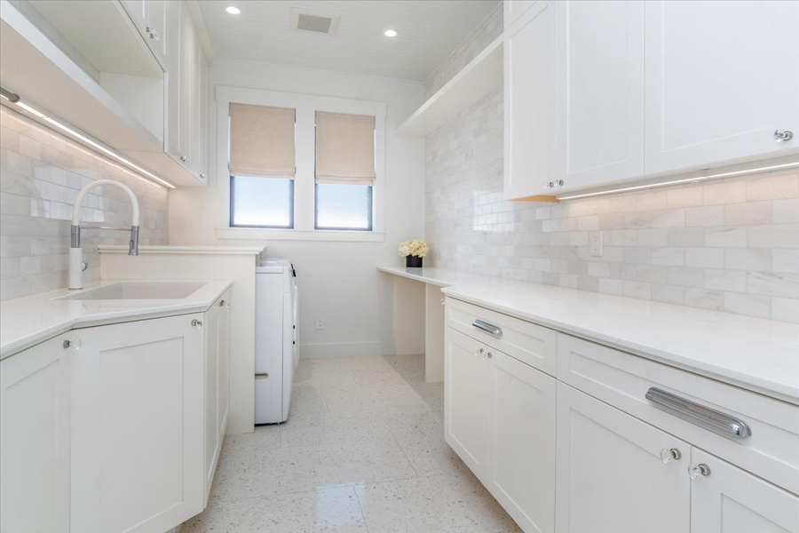 Bright utility space with ample counter area and integrated laundry facilities.