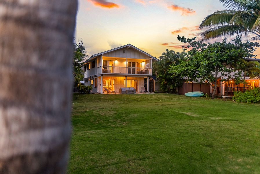 Evening falls over the retreat, with golden skies and lush lawn.