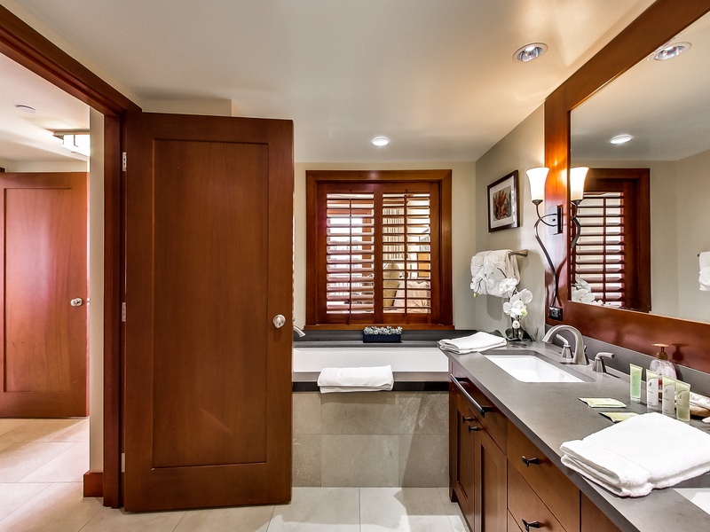 The primary guest bathroom features a walk-in shower and luxurious soaking tub.