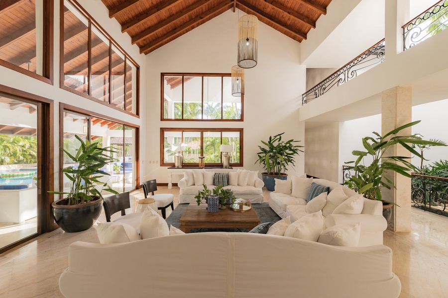 Spacious living area with high wooden ceilings and abundant natural light, perfect for relaxation and socializing.