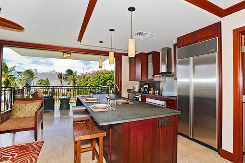 A fully equipped kitchen with bar seating and stainless steel appliances.