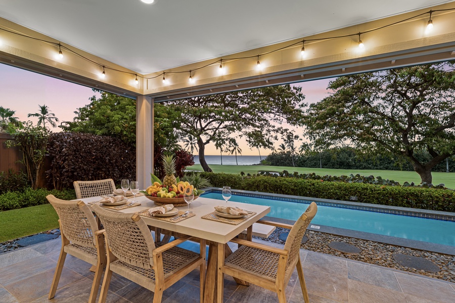 A set table under the lanai lights is where dinner runs long.