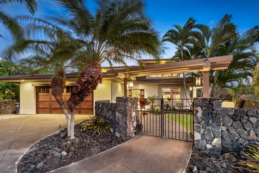 Grand gated entrance framed by palm trees, welcoming you to this tropical retreat.