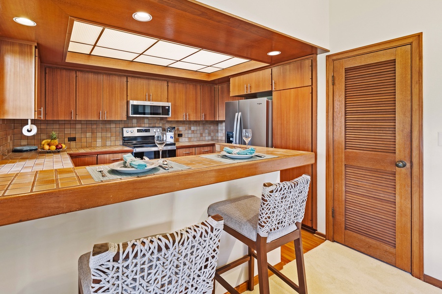 The kitchen's breakfast bar offers a casual spot for enjoying meals or morning coffee, complete with modern appliances