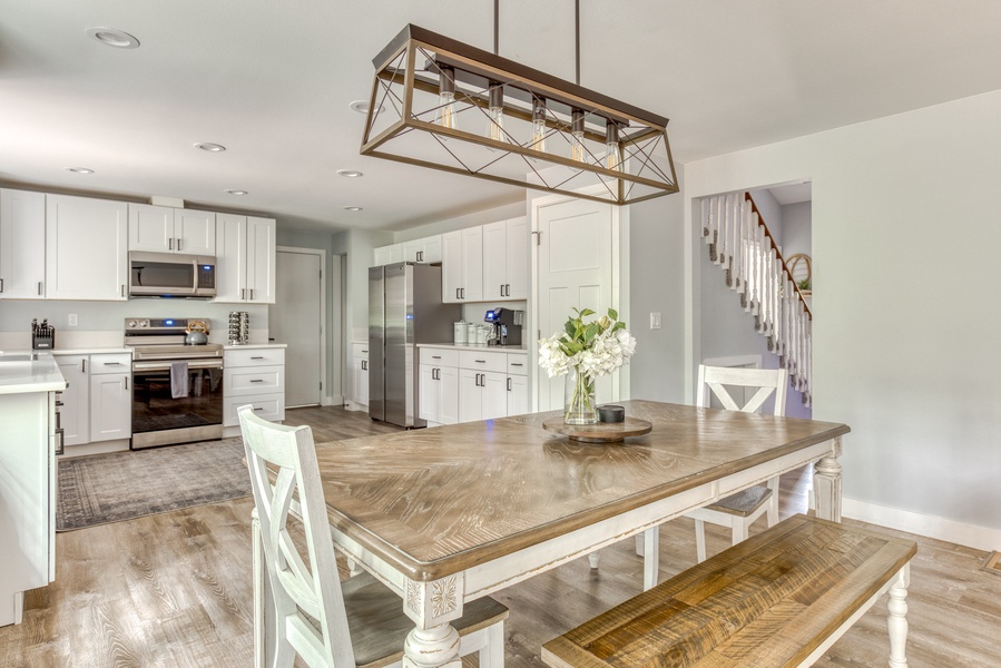 Rustic charm blends with modern elegance in this spacious kitchen and dining area, complete with a statement lighting fixture.