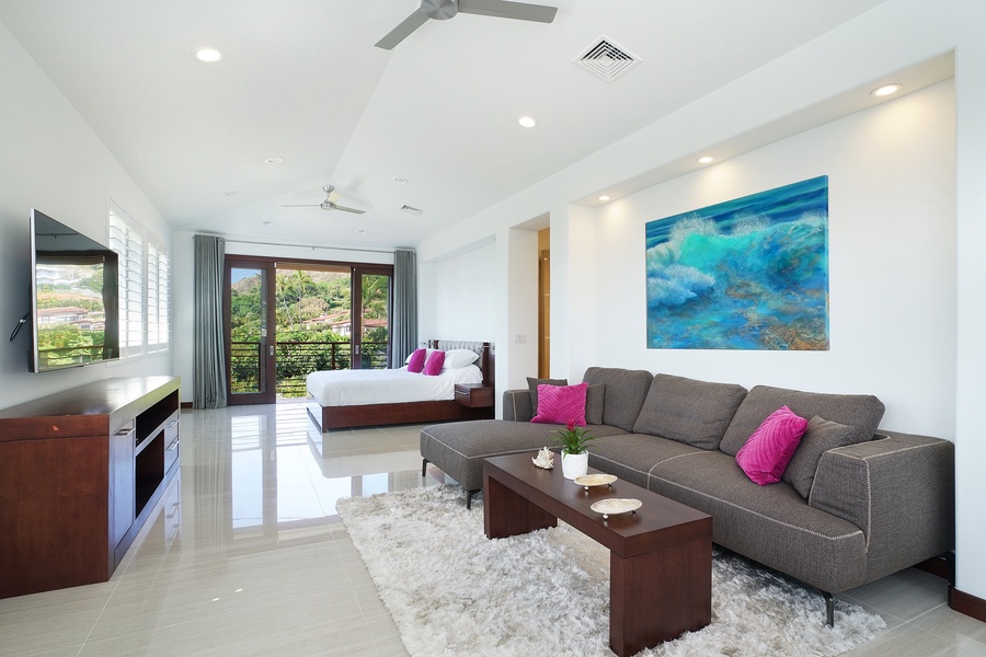 Bright primary bedroom with plush sectional, stylish decor, and serene views.