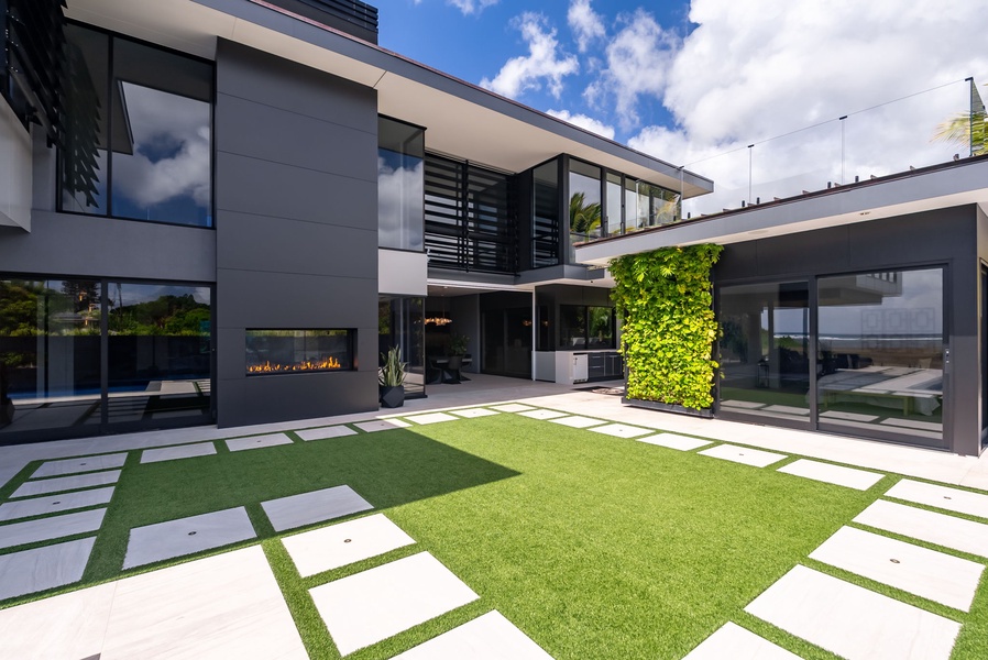 Contemporary villa centered around a landscaped courtyard and outdoor fireplace.