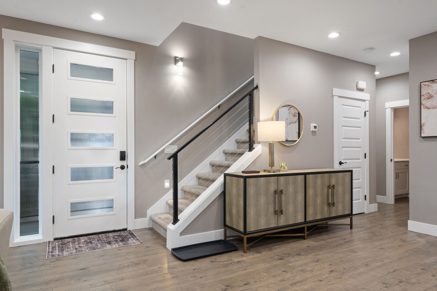 Stylish entryway with gleaming hardwood floors, modern lighting, and elegant furnishings that welcome you home.