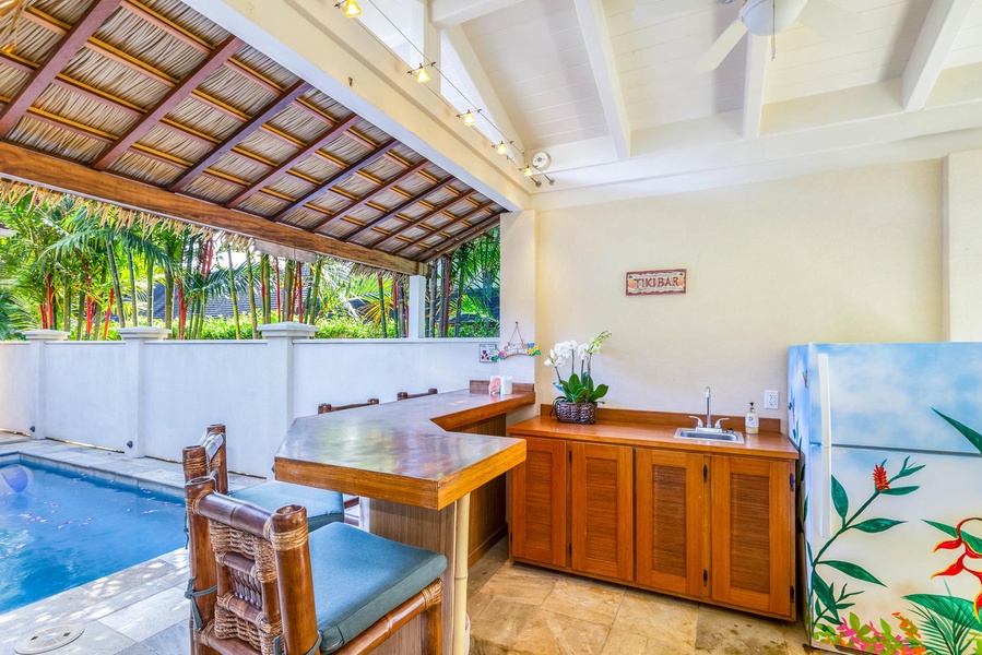 Island-style tiki bar next to the pool offers the perfect setting for tropical drinks and poolside fun.