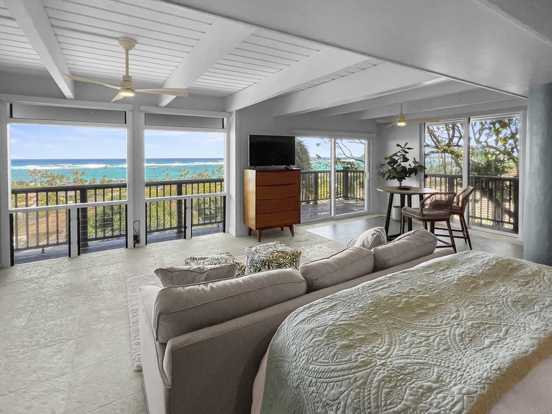 Guest bedroom has a flat screen TV, sweeping ocean views, and a private seating area