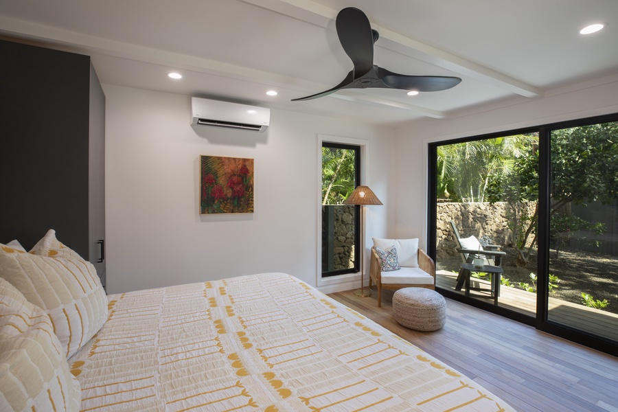 Minimalist fourth guest bedroom design with warm tones and large glass doors connecting to nature.