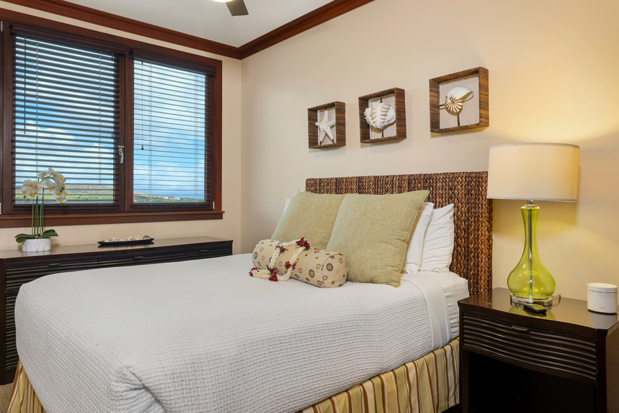 The guest bedroom features a queen bed and natural lighting.