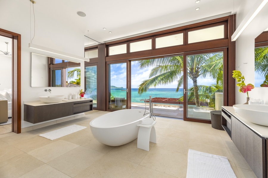 Spa-like primary bathroom with a soaking tub and walk-in shower, complete with oceanfront scenery.