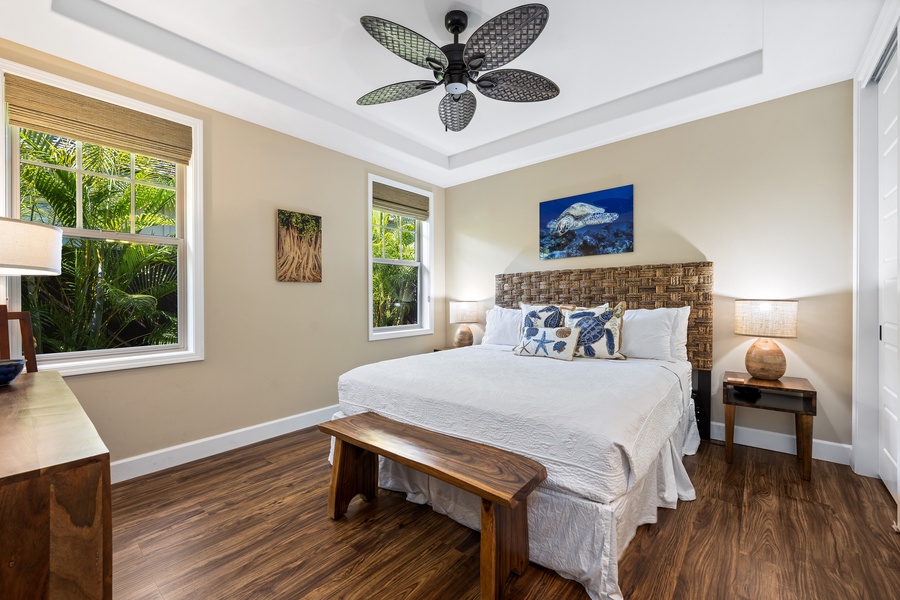 Rest easy in the first guest suite at Kona Blue Vacations Holua Kai, featuring a king bed and ceiling fan.