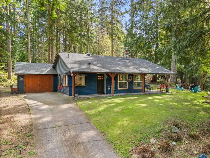 The home’s charming facade welcomes you with vibrant color and lush greenery, setting the tone for a restful retreat.