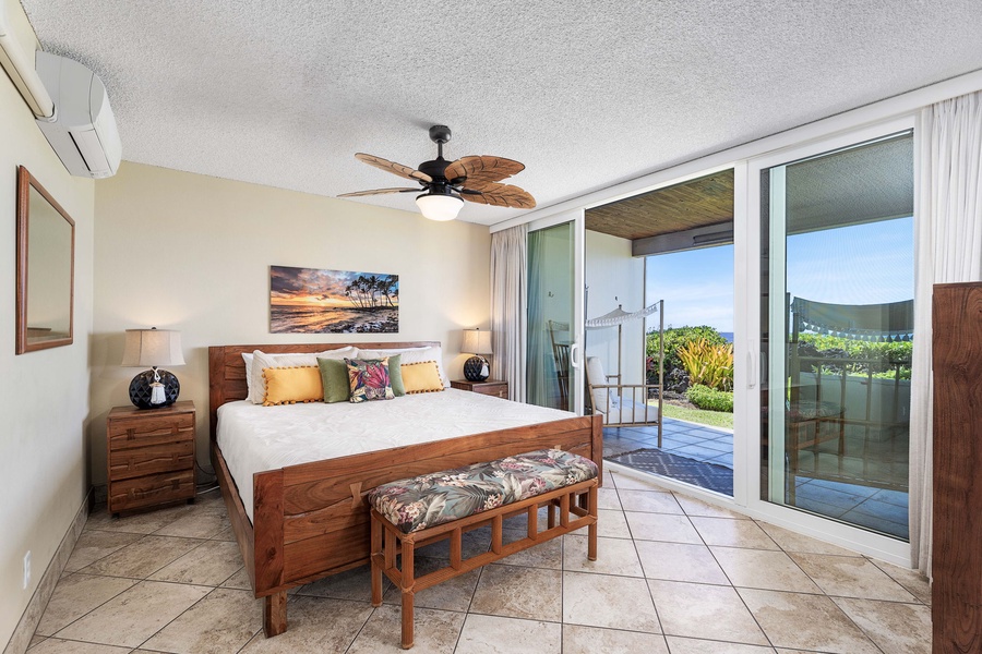 Spacious primary suite with a plush king size bed and direct lanai access for a relaxing retreat.